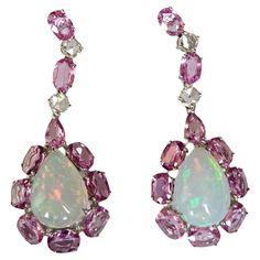 A very gorgeous and beautiful, Opal & Pink Sapphires Chandelier Earrings set in 18K White Gold & natural Diamonds. The weight of the Ethiopian Opals is 6.12 carats. The weight of the Pink Sapphires is 7.60 carats. The Pink Sapphires are of Ceylon (Sri Lanka) origin. The Diamonds weight is 0.64 carats. Net 18K White Gold weight is 7.20 grams. The Gross weight of the Earrings is 10.06 grams. The dimensions of the Earrings are 4.30cm x 1.60cm x 1.00cm (L x W x D). The Earrings have a push back. Fea Luxury Pink Opal Round Jewelry, Luxury Pink Halo Setting Earrings, Luxury Multicolor Temple Jewelry Earrings, Luxury Ethiopian Opal Teardrop Jewelry, Diamond Chandelier Earrings, Diamond Chandelier, Ethiopian Opal Ring, Blue Sapphire Diamond, Exclusive Jewelry