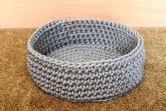 a gray crocheted bowl sitting on top of a rug