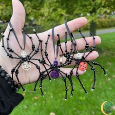 a person's hand holding several bracelets with beads and charms attached to them