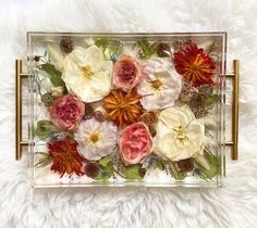 a glass tray with flowers in it on a white furnishing area next to a rug