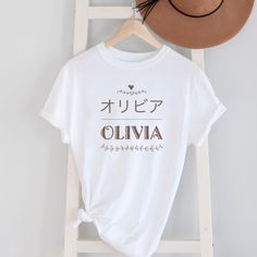 You can customize T-shirt with your name in Japanese! Or this personalized gift will be nice gift for Japanese students, anime fans, whoever loves Japanese culture!  Depending on the length of your name, it might look slightly different from the examples.   After I receive an order, I will send a mock up image to you for confirmation. Please reply and let me know if it looks fine/something needs to be changed, or if I don't hear from you by the time I specify, I will proceed the order with the mock up design. The color may be slightly different from the actual color due to the lighting effect and computer monitor. HOW TO ORDER 1. Select the shirt Size. 2.Select the shirt Color/font color. 3. Fill out personalization  Enter your name that you want on the T-shirt. 4. Click Add to cart.  If y Custom Name Cotton T-shirt As Gift, Custom Name White Crew Neck T-shirt, Custom Print White T-shirt For Personalized Gift, Customizable White T-shirt For Personalized Gift, White Crew Neck T-shirt With Custom Name, White Short Sleeve T-shirt With Custom Name, Personalized Name Print Short Sleeve T-shirt, Personalized Cotton T-shirt With Custom Text, Personalized Cotton T-shirt