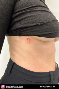 a woman's stomach with a small apple tattoo on her lower back and side