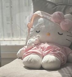 a hello kitty stuffed animal laying on top of a pillow