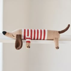 a crocheted dog is laying on the shelf