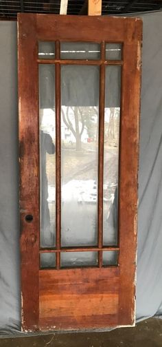 an old wooden door with glass on the front and side doors are being painted brown