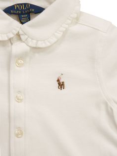 This garment boasts the sophistication of an Oxford shirt with the comfort and practicality of breathable cotton pique. Ralph Lauren works with Better Cotton to improve cotton farming around the world. - Exclusive multicoloured embroidered pony on left chest - Club neck with ruffle trim - Button placket - Long sleeves - Buttoned and pleated cuffs with ruffle trim DESIGNER ID: 312901132 002Composition: 100% Cotton Embroidered Cotton Collar Tops, Embroidered Cotton Collared Tops, Classic Cotton Tops With Embroidered Logo, White Long Sleeve Shirt With Embroidered Logo, Classic Cotton Shirt With Embroidered Logo, Long Sleeve Cotton Polo Shirt With Embroidered Logo, Embroidered Cotton Polo Collar Tops, Classic Embroidered Collared Tops, Classic Embroidered Cotton Tops