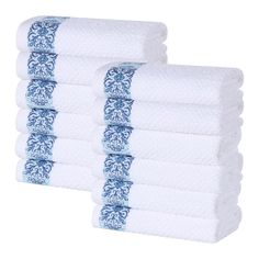 four white towels stacked on top of each other in front of a white background with blue designs