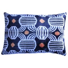 a blue pillow with orange and white designs on it