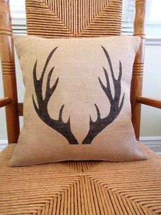 a pillow with antlers on it sitting on a chair