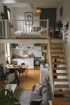 a living room filled with furniture next to a staircase leading up to a loft bed