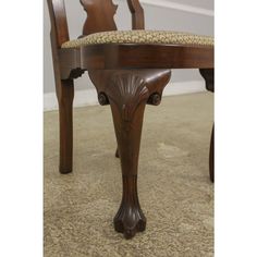 a wooden chair sitting on top of a carpeted floor