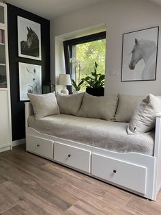 a white couch sitting on top of a hard wood floor next to a large window