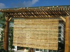 a bamboo covered pergola in front of a building