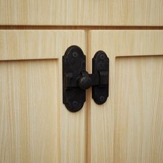 a close up of a wooden door with two black latches on the front and back doors