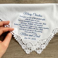 someone is holding up a white handkerchief with the words, mom and dad on it