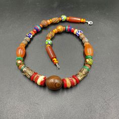 a beaded necklace with wooden beads on a gray surface