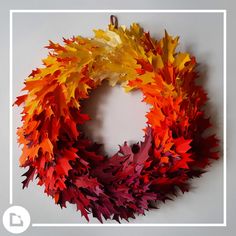 a wreath made out of autumn leaves on a wall