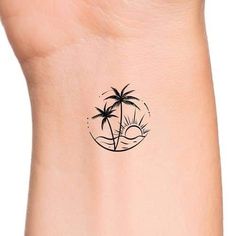 a small palm tree tattoo on the right side of the ankle, with an island in the background