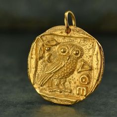 Satin 24K Gold Plated Ancient Coin with Athena's Owl NecklaceA lovely replica of an ancient Greek coin. In Greek mythology, Athena is the goddess of war, wisdom, strength, crafts, justice and skill. In Homeric poetry, Athena's most common epithet translates to "bright-eyed" or "with gleaming eyes," much like an owl. Many scholars argue that Athena is the owl herself - she is wisdom. 40 micro inches of 24K gold plated over bronze Can buy pendant only or on a matching gold plated necklace chain in Greek Mythology Athena, Athena Owl, Greek Mythology Jewelry, Mythology Jewelry, Ancient Coin Jewelry, Thick Necklace, Ancient Greek Coin, Ancient Coin, Greek Coins