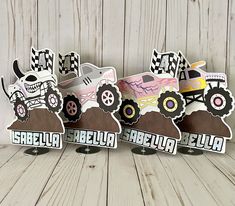 three cardboard monster trucks are sitting on top of each other in front of a wooden wall