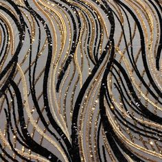 black and gold sequins on fabric with wavy lines in the background, closeup