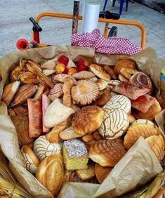 a basket filled with lots of different types of pastries on top of a table