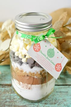 a mason jar filled with cookies and marshmallows for the holiday cookie mix in a jar recipe