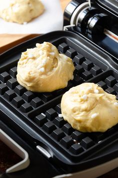 two doughnuts sitting on top of a black grill