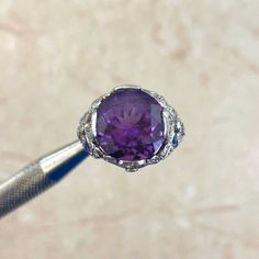 a close up of a purple diamond ring