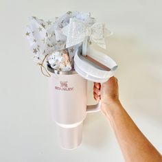 a person is holding a cup with some decorations in it and the lid has been opened