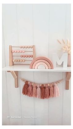 a shelf that has some items on it and is decorated with pink tassels