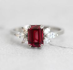 The Janine ring with gorgeous umba garnet and marquise white diamonds on the side, is truly a ring that will not go unnoticed. With it’s jaw dropping beautiful red color it is mesmerising and any lady would be happy to have this as her engagement ring. Details Center stone Gemstone: Natural Umba valley garnet Color: re Garnet Color, Garnet And Diamond Ring, Garnet Engagement Ring, Ring With Diamond, Garnet Ring, Dream Board, Garnet Rings, Diamond Cluster, White Diamonds