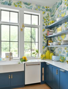 a kitchen with blue cabinets and yellow flowers on the wall