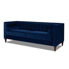 a blue velvet couch with wooden legs