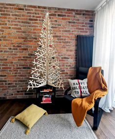 a living room with a brick wall and a christmas tree on the floor next to a chair