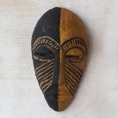 an african mask hanging on the wall