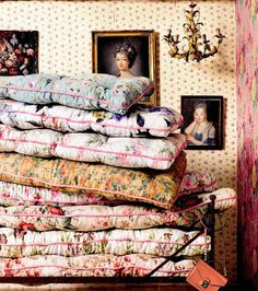 a stack of pillows sitting on top of a wooden table next to a framed photo