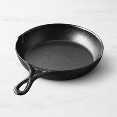 an empty frying pan sitting on top of a white counter