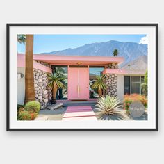 a pink door in front of a house with palm trees and mountains in the background