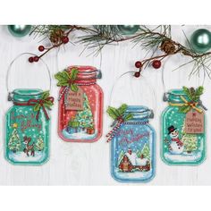 three mason jars with christmas decorations hanging from the front and bottom, one has a snowman in it