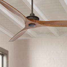 a ceiling fan with wooden blades in a room