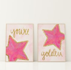 two pink and gold star paintings with the words you're golden written on them