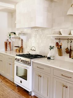 a white stove top oven sitting inside of a kitchen