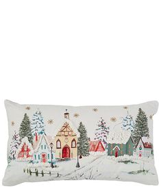 a white pillow with a christmas village scene on the front and sides, along with snow covered trees