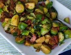 brussel sprouts and bacon on a white plate with a silver spoon