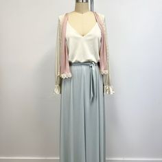 Vintage maxi dress with vest featuring; a deep v neckline long sleeves with elastic at wrist and 3 inch ruffle at cuff elastic waist, with tie belt skirt falls to the floor vest is trimmed with lace and hits high on the hip of a silky, lightweight, 100% polyester in light blue, dusty rose and off white this has not labels or tags, measurements when laid out flat are; 18 1/2 inches from pit to pit 22 inch sleeves plus 3 inch ruffle 13 inches stretching to  19 inches at the waist 26 inches at the Elegant Fall Dresses With Elastic Waistband, Spring Evening Dress With Elastic Waistband, Elegant V-neck Dress With Elastic Waistband, Elegant Ruffled Maxi Skirt For Fall, Elegant Ruffled Maxi Skirt For Daywear, Elegant V-neck Maxi Dress With Elastic Waistband, Retro Flowy V-neck Maxi Dress, Chic V-neck Maxi Dress With Lace Trim, Vintage Silk V-neck Maxi Dress