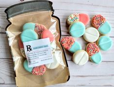 some cookies are in a bag and on the table next to it is a jar of sprinkles