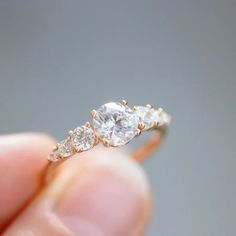 a person holding a diamond ring in their hand