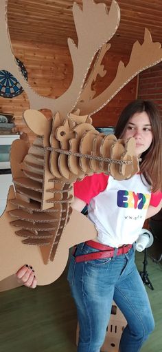 a woman standing next to a cardboard cutout of a moose's head and antlers