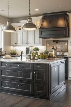 a large kitchen with an island in the middle and two pendant lights hanging from the ceiling